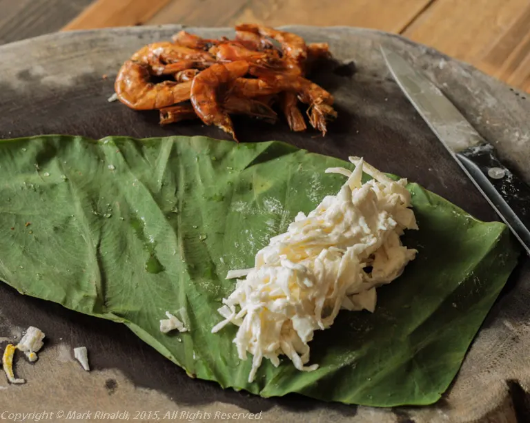 Sheets of taro leaf are filled with grated taro root and rolled like little cigars.